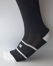 Calzini lunghi neri dettaglio sul piede con logo IGS bianco